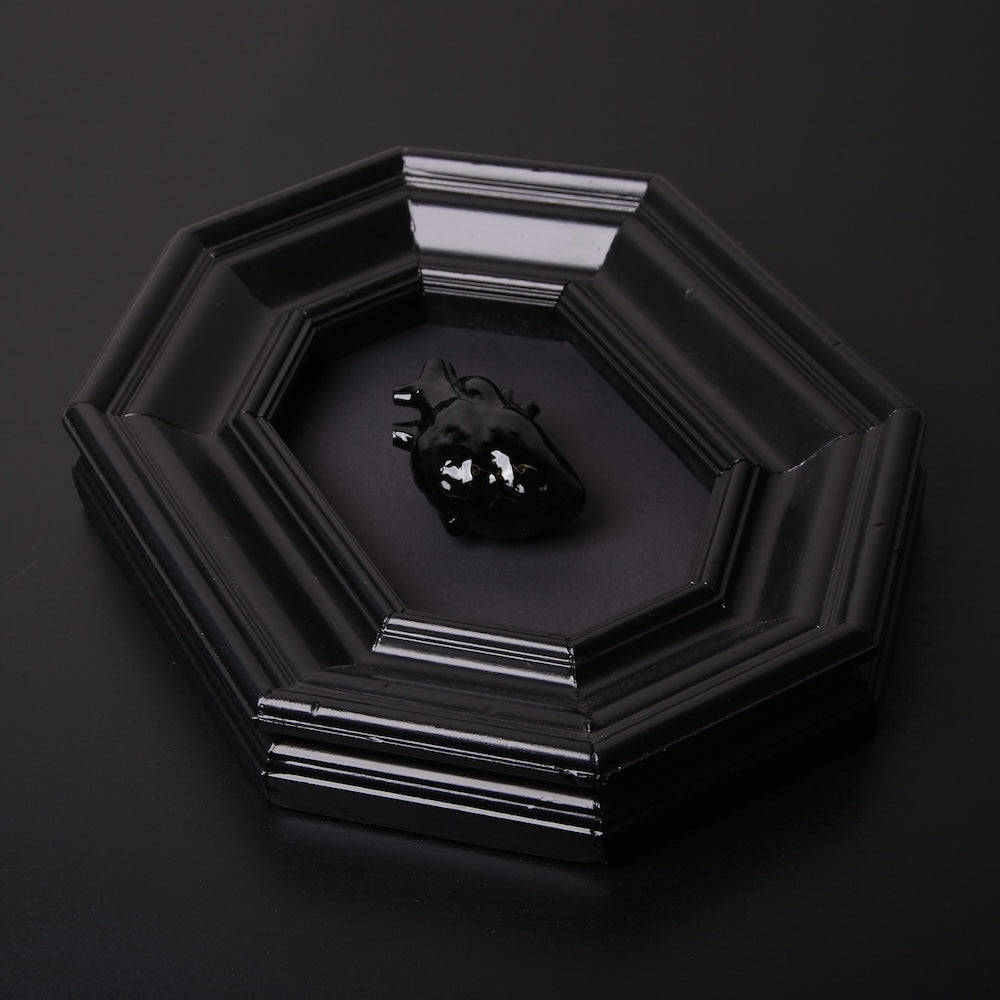 quadro con cornice ottagonale e cuore anatomico nero, vista dall'alto