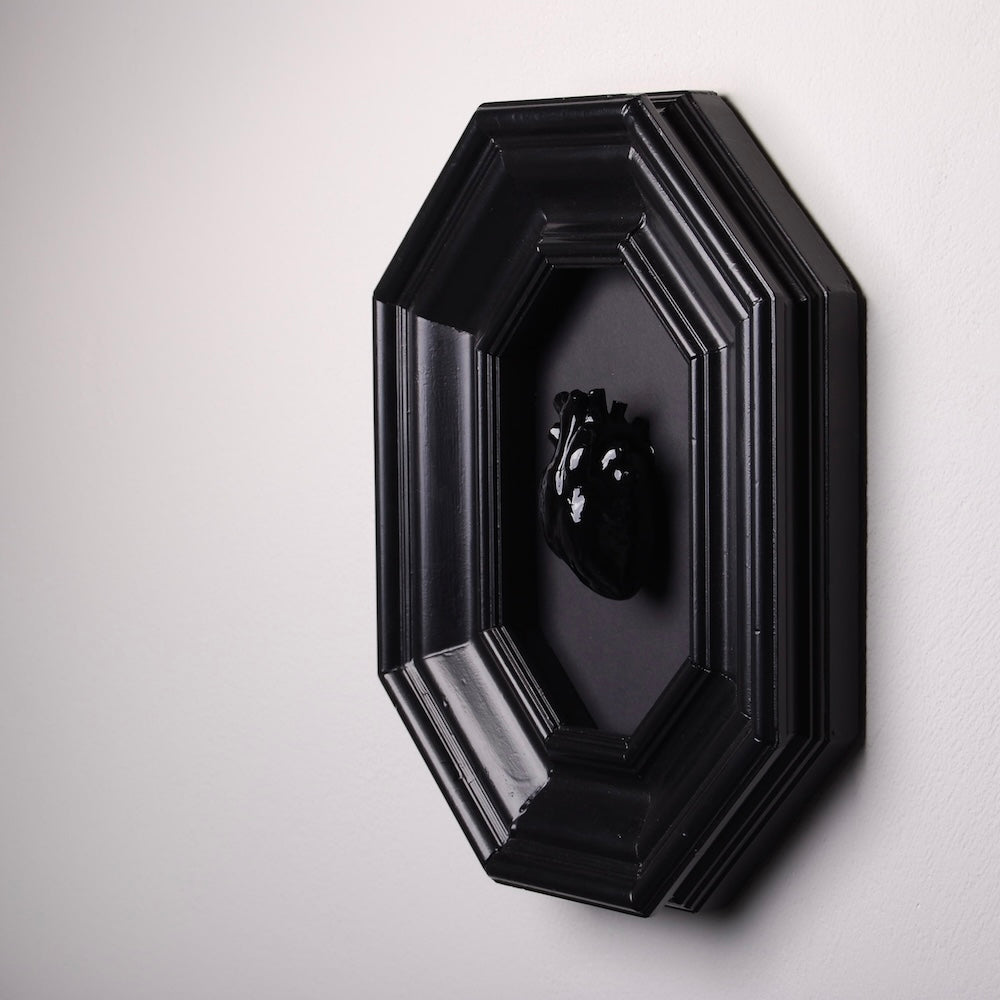 quadro con cornice ottagonale e cuore anatomico nero, vista 3/4