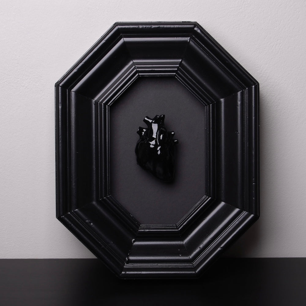quadro con cornice ottagonale e cuore anatomico nero, vista frontale