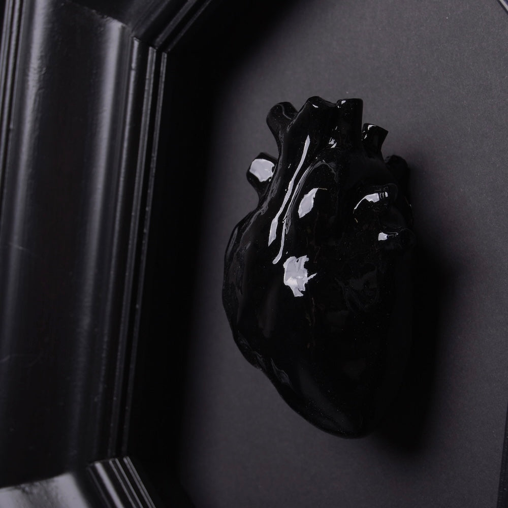 quadro con cornice ottagonale e cuore anatomico nero, particolare ravvicinato del cuore