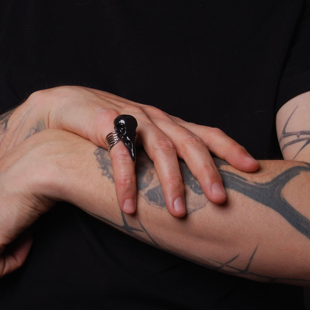 Anello teschio di corvo nero indossato su mano maschile