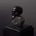 anello con teschio nero poggiato su porta anelli