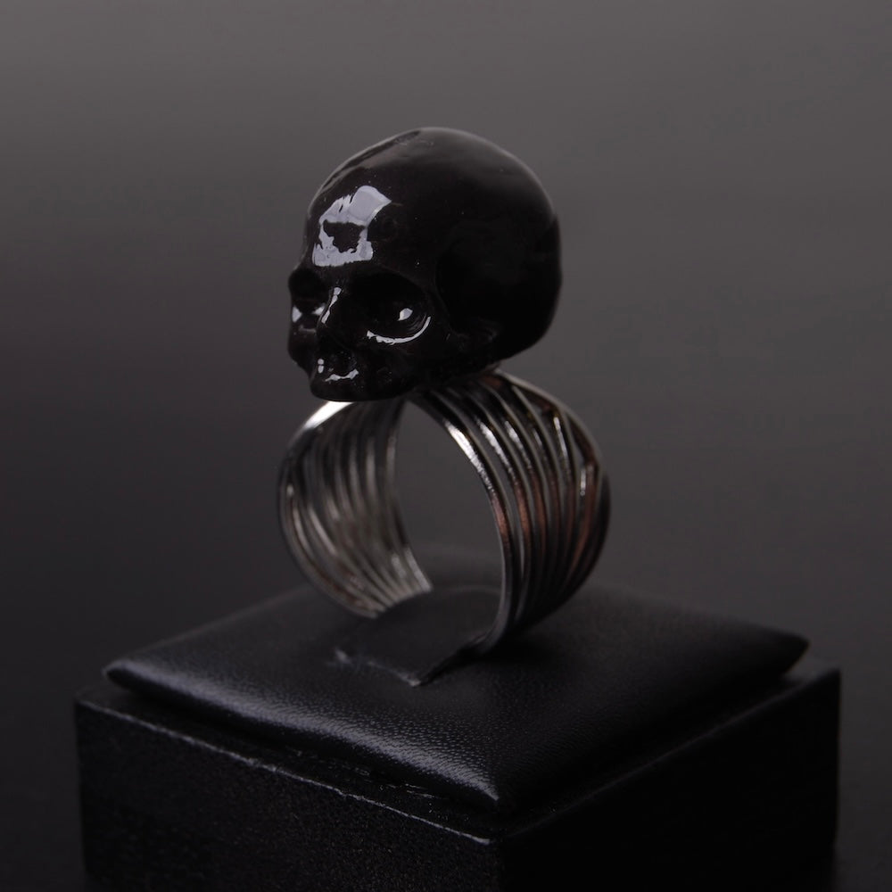 anello con teschio nero poggiato su porta anelli