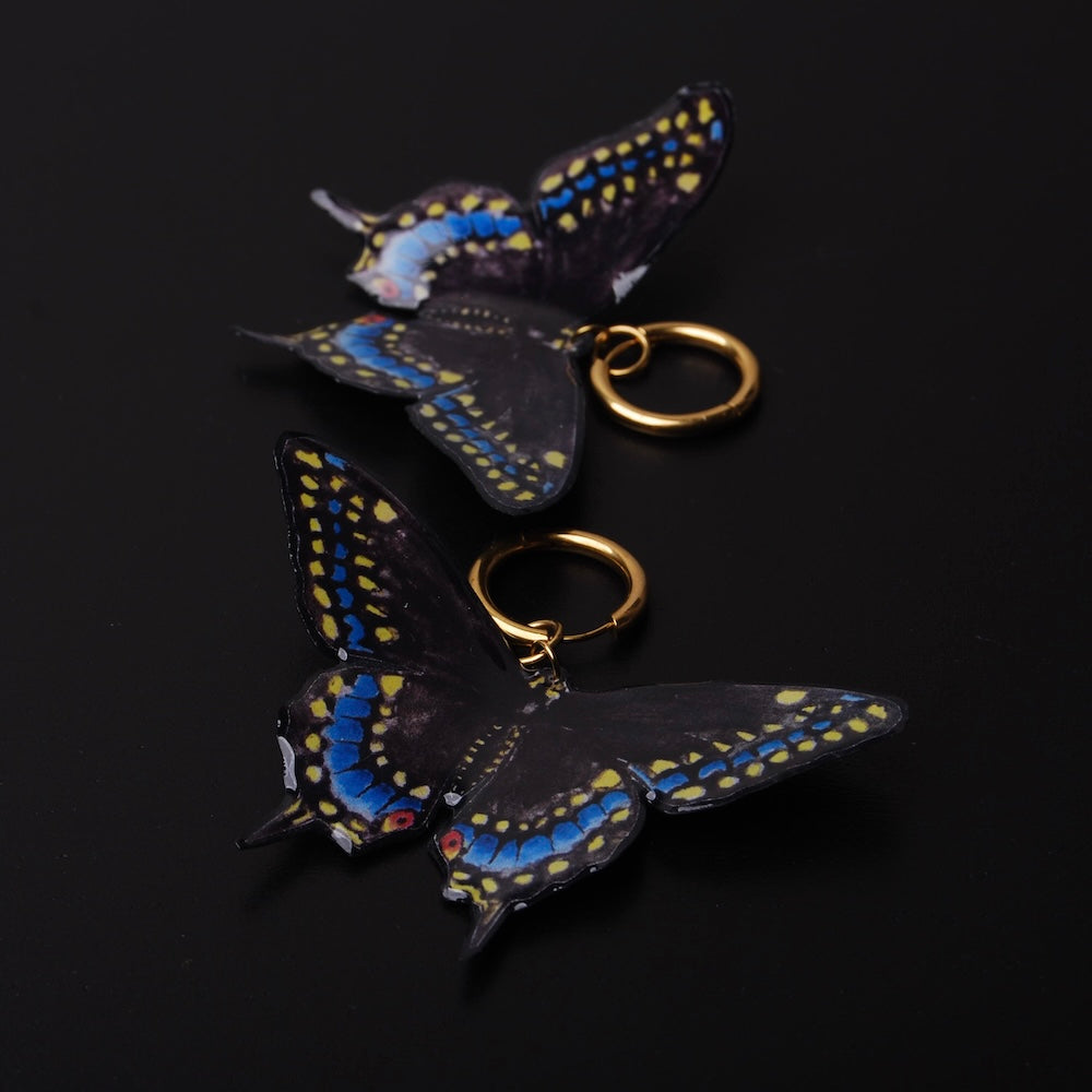 orecchini a cerchio con farfalla black swallowtail su sfondo nero