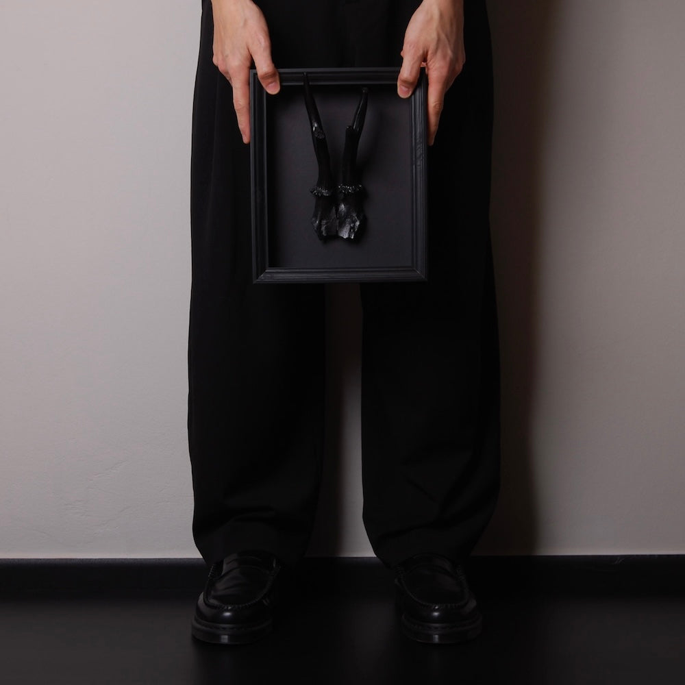 mani che sorreggono un quadretto con riproduzione corna di capriolo