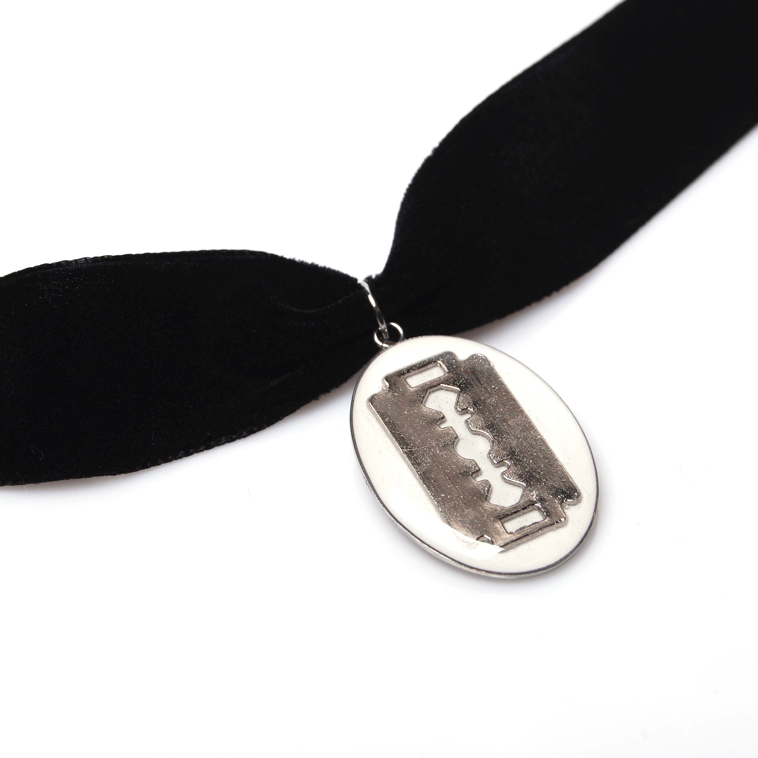 particolare del pendente ovale con charm lametta di un choker in velluto nero