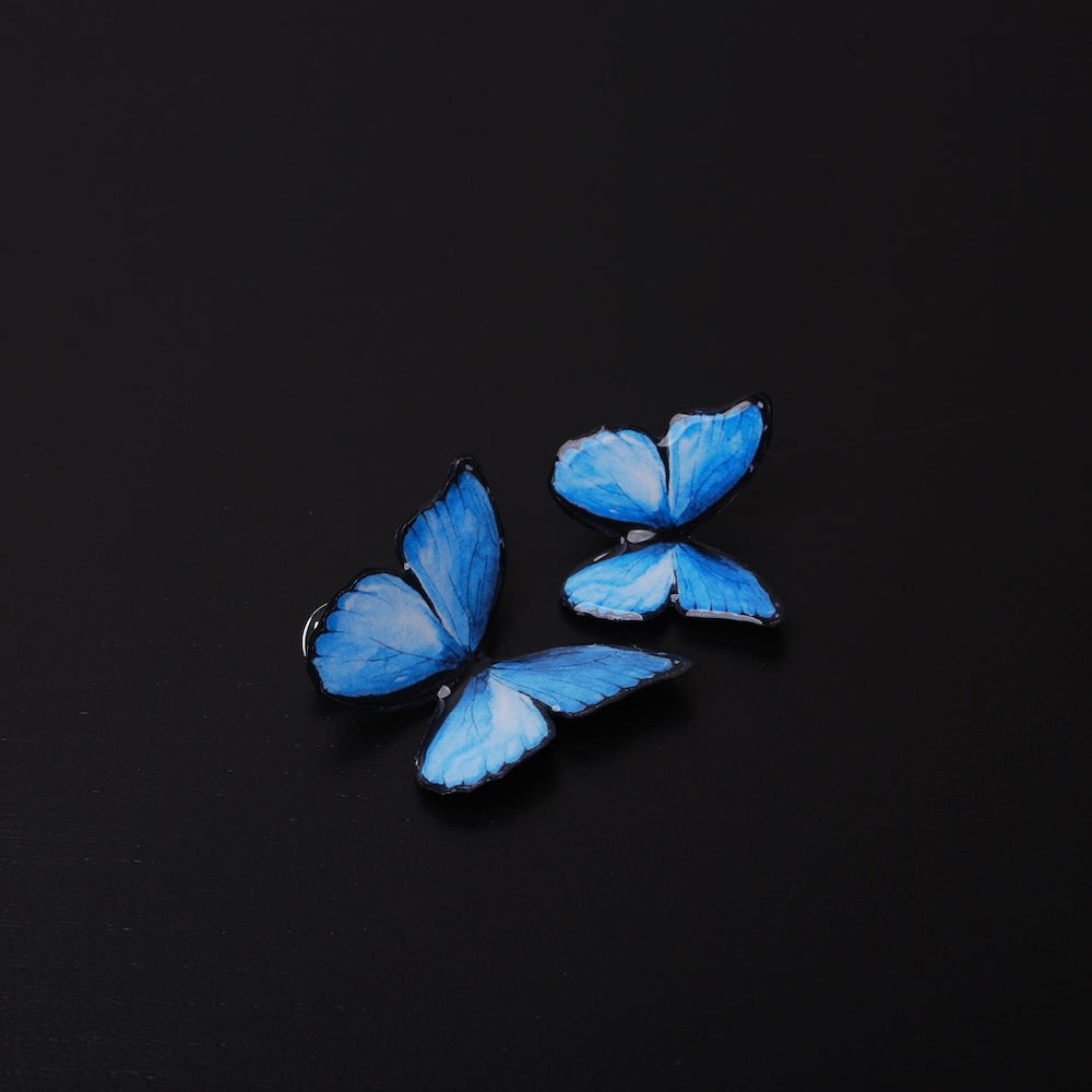 due spille farfalla blu, vista frontale dall'alto
