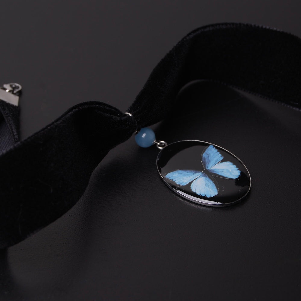 choker in velluto nero con pendente ovale con farfalla blu