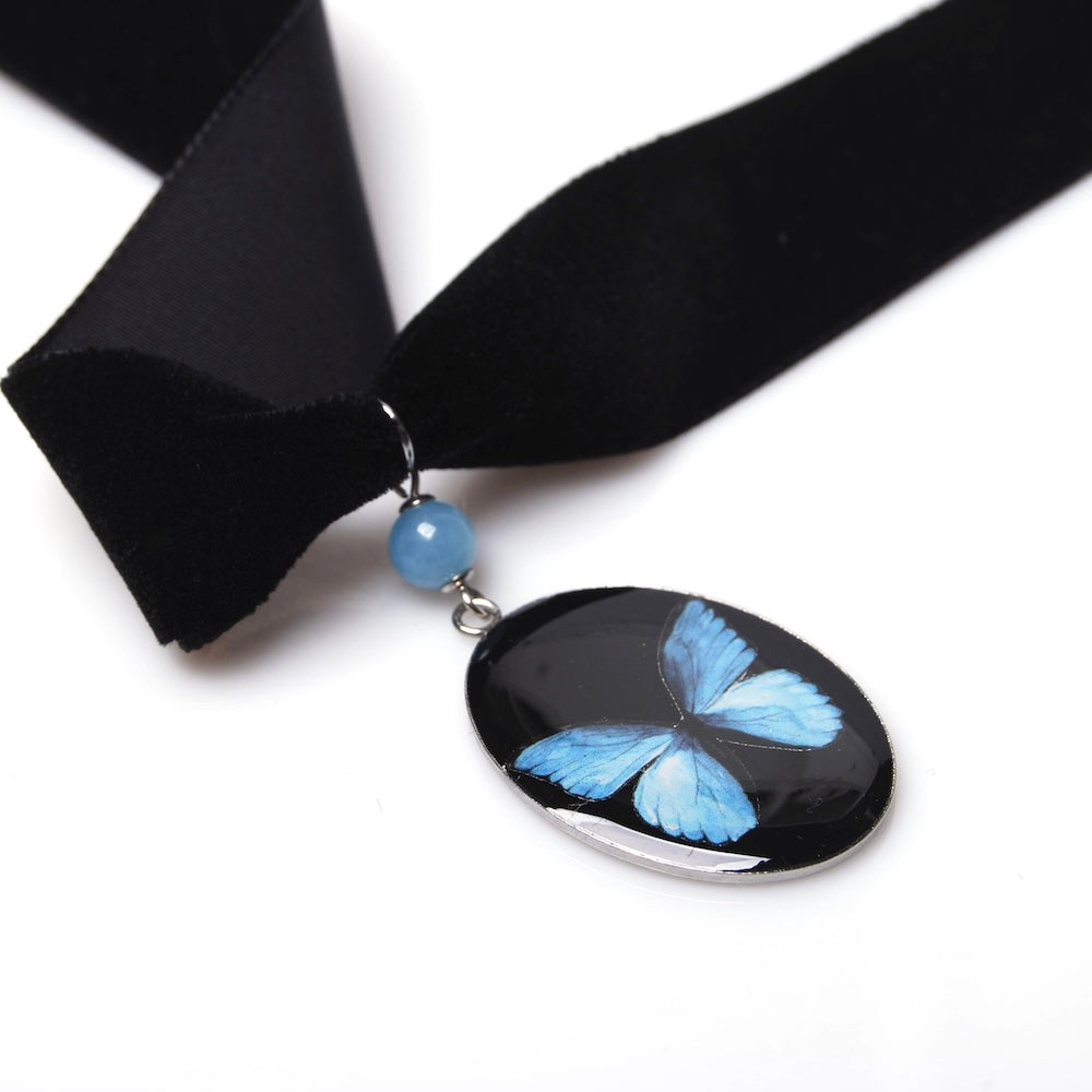 pendente ovale con farfalla blu appeso a choker in velluto nero con perlina di acquamarina