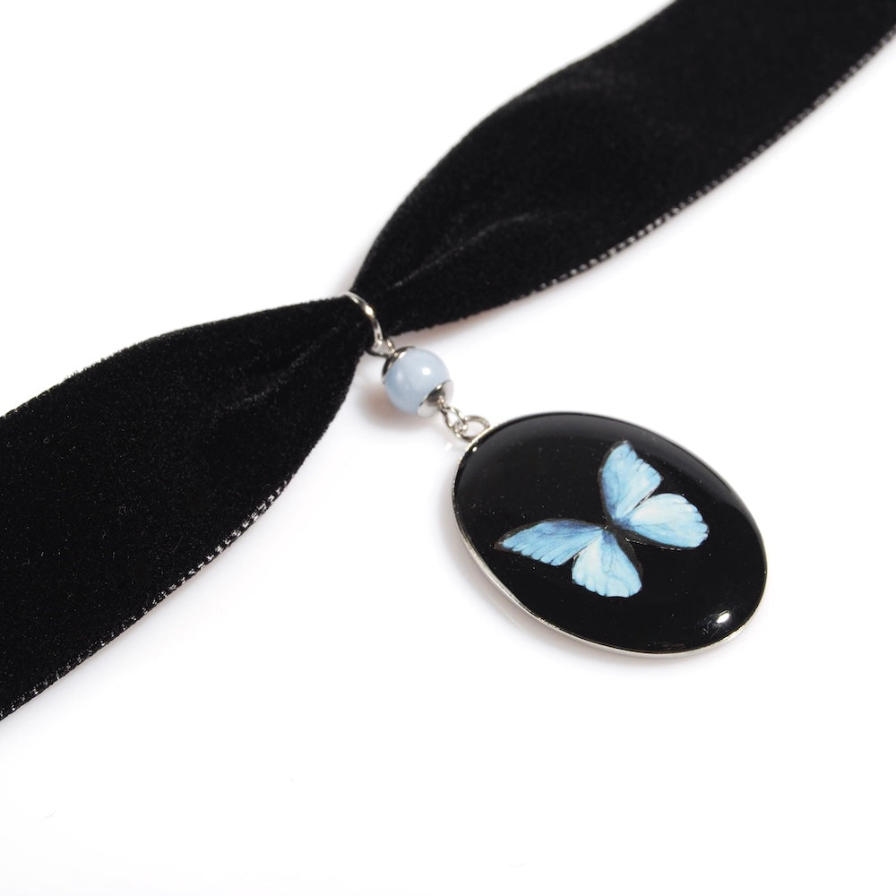 choker in velluto nero con pendente ovale e farfalla blu vista 3/4