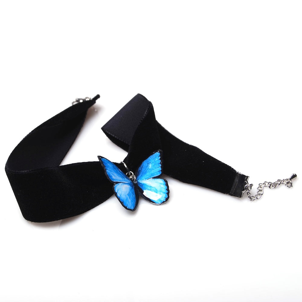 choker in velluto nero con pendente farfalla blu, vista dall'alto