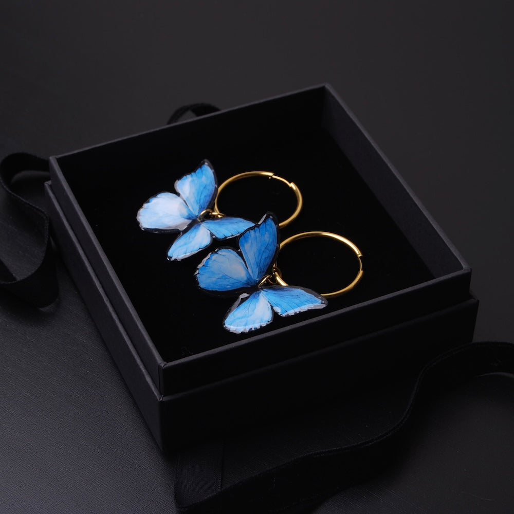 orecchini a cerchio con farfalle blu dentro una scatolina nera