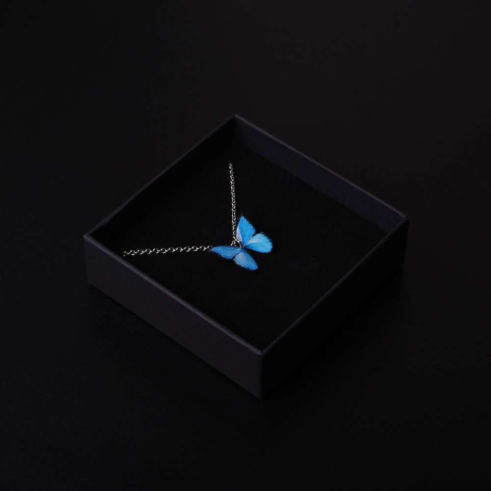 collana con farfalla blu dentro una scatola regalo nera