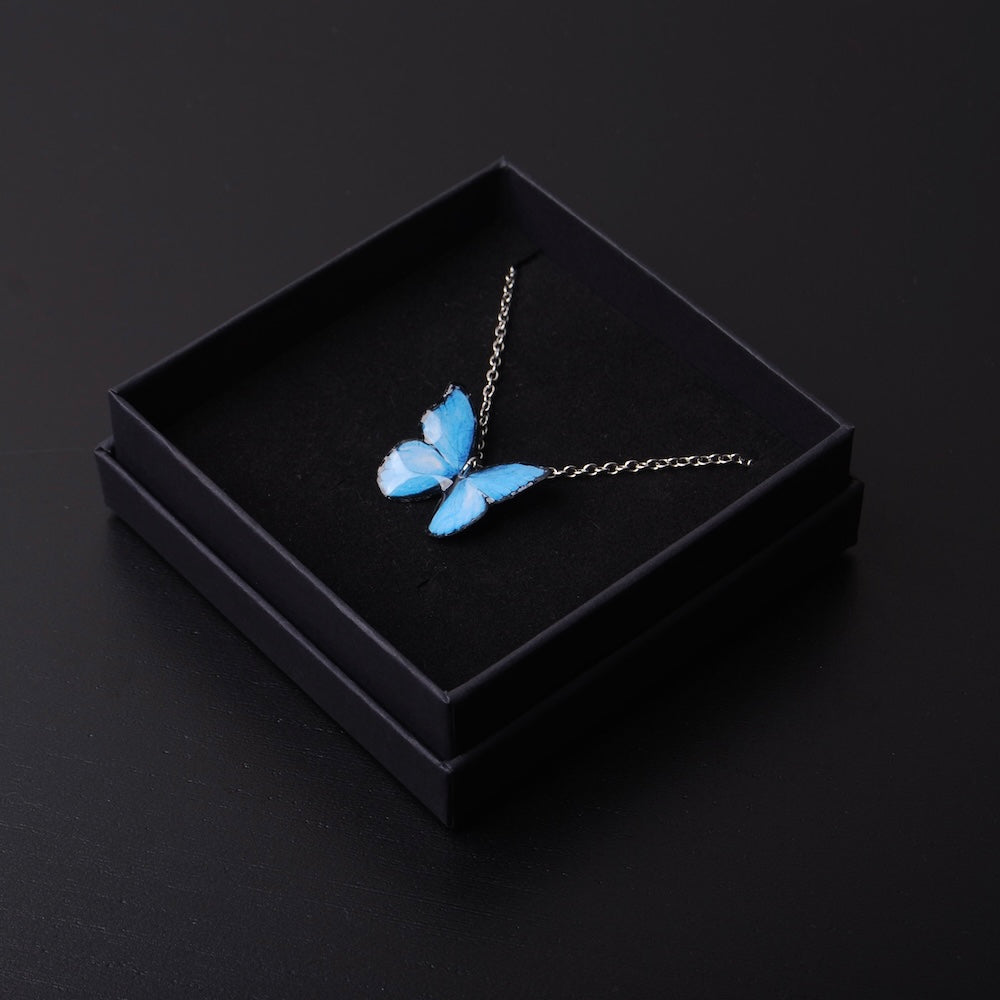 collana con farfalla blu su scatolina nera