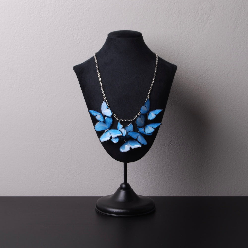collana con sciame di farfalle blu su espositore per collane