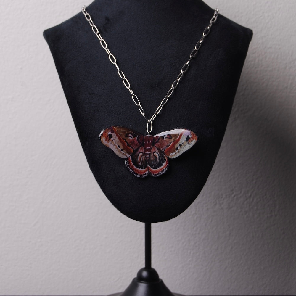 collana con pendente falena su espositore per collane nero