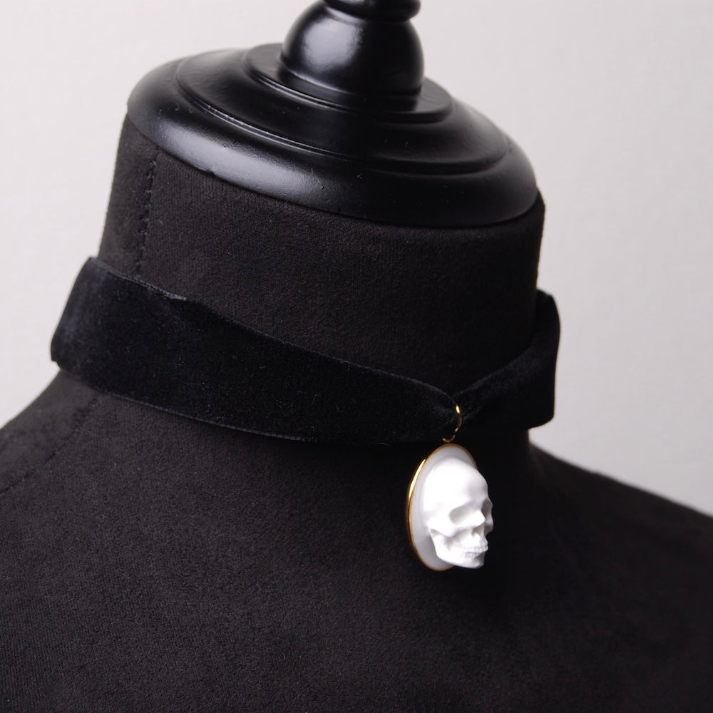 choker in velluto nero con pendente ovale teschio cammeo su busto espositore in velluto nero, vista 3/4