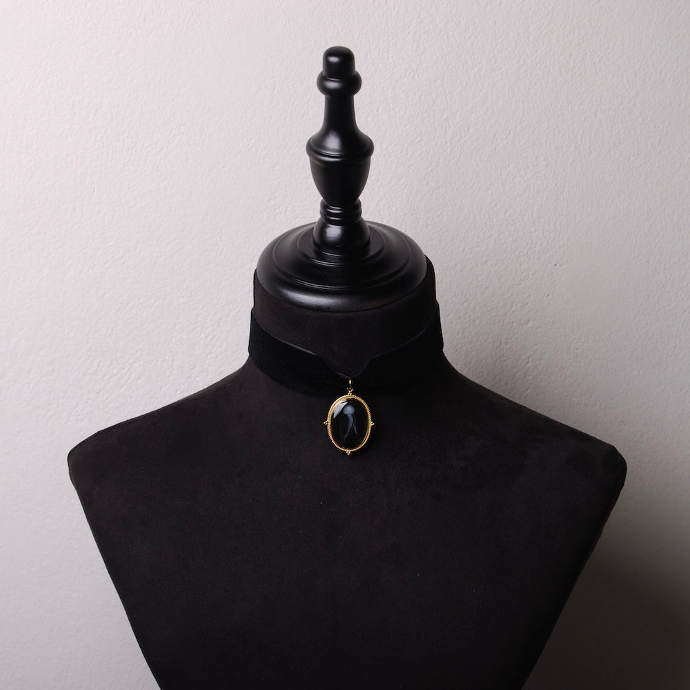 choker in velluto nero con pendente ovale e medusa marina inglobata sotto resina, su busto espositore in velluto nero
