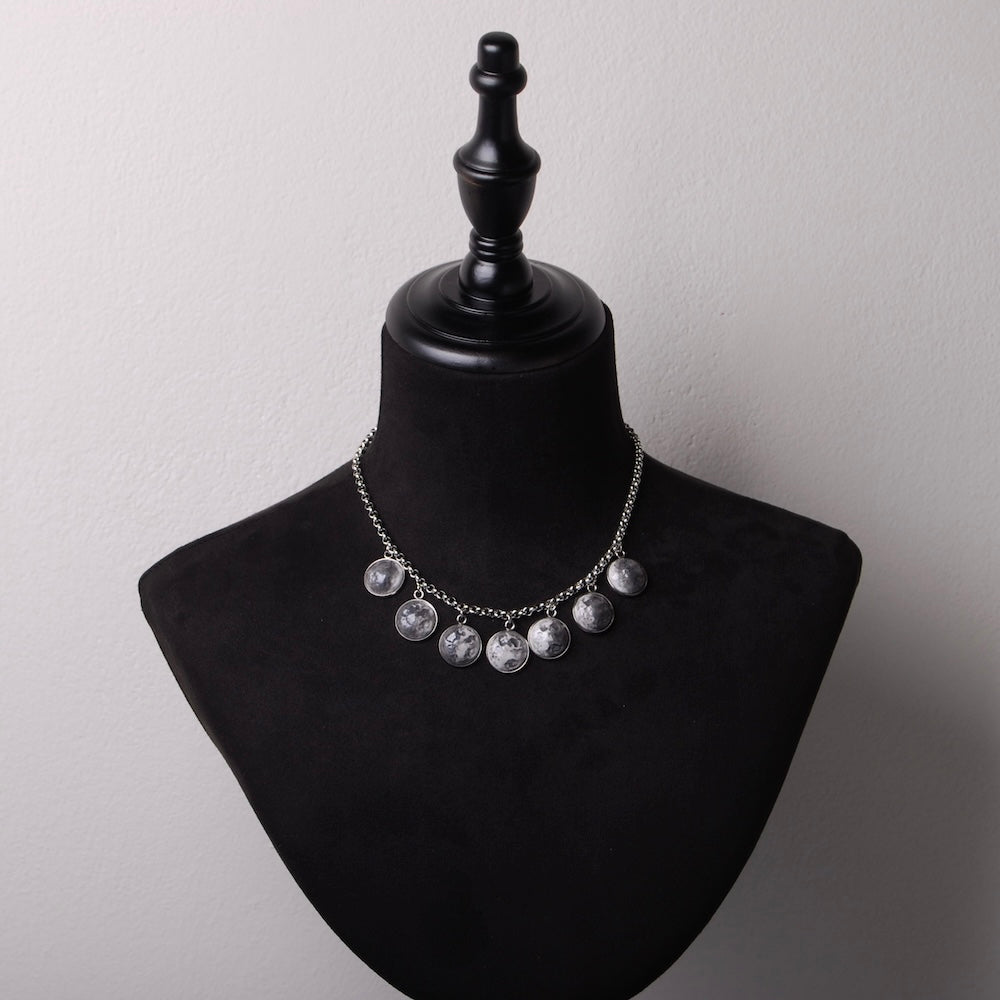 collana con 7 pendenti a fasi lunari su busto espositore in velluto nero