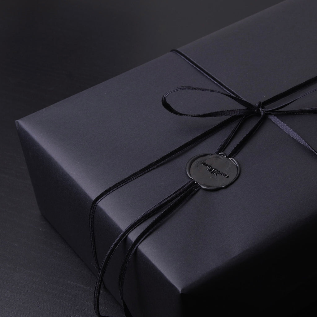 confezione regalo nera con nastro in velluto nero e sigillo in ceralacca