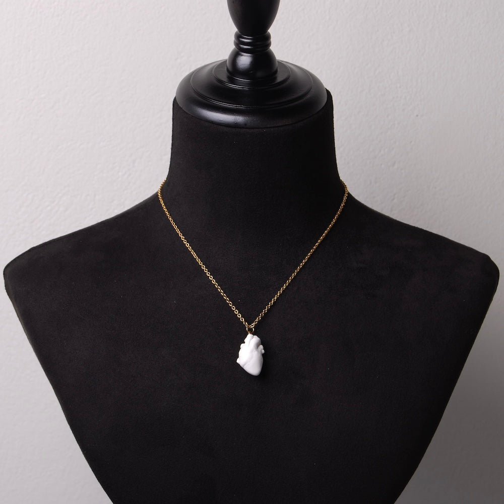 collana a catena sottile con cuore anatomico bianco pendente, su busto espositore in velluto nero
