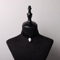 choker in velluto nero con pendente teschio cammeo su busto espositore in velluto nero
