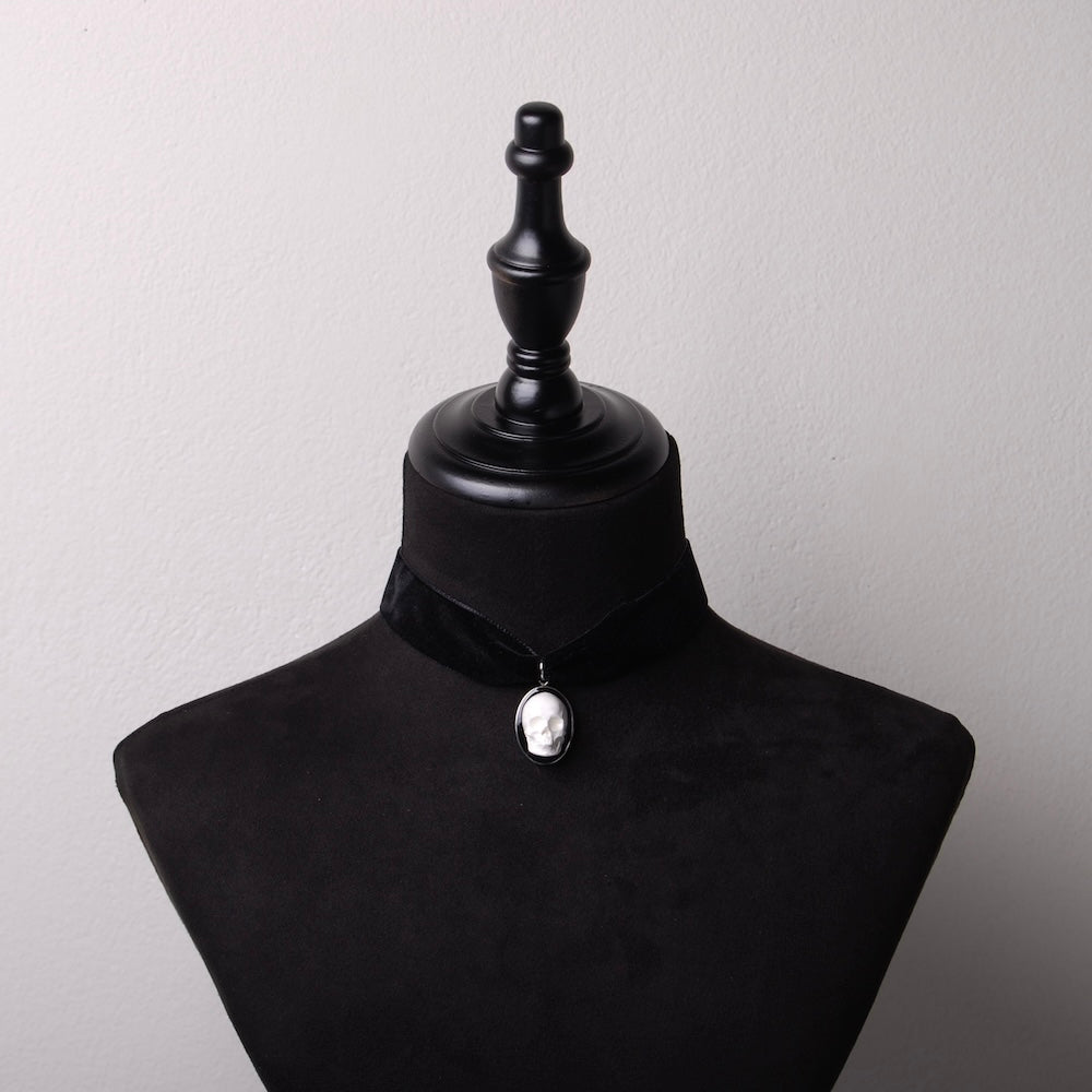 choker in velluto nero con pendente teschio cammeo su busto espositore in velluto nero