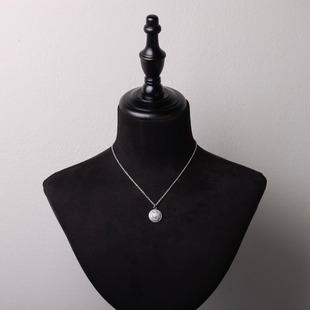 collana catena sottile con pendente luna piena su busto espositore in velluto nero
