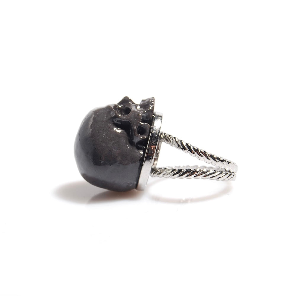 anello con teschio grigio scuro, poggiato sul retro