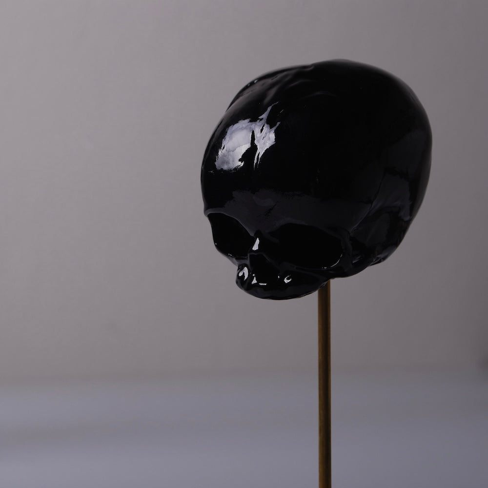 piccolo teschio nero su piedistallo sottile