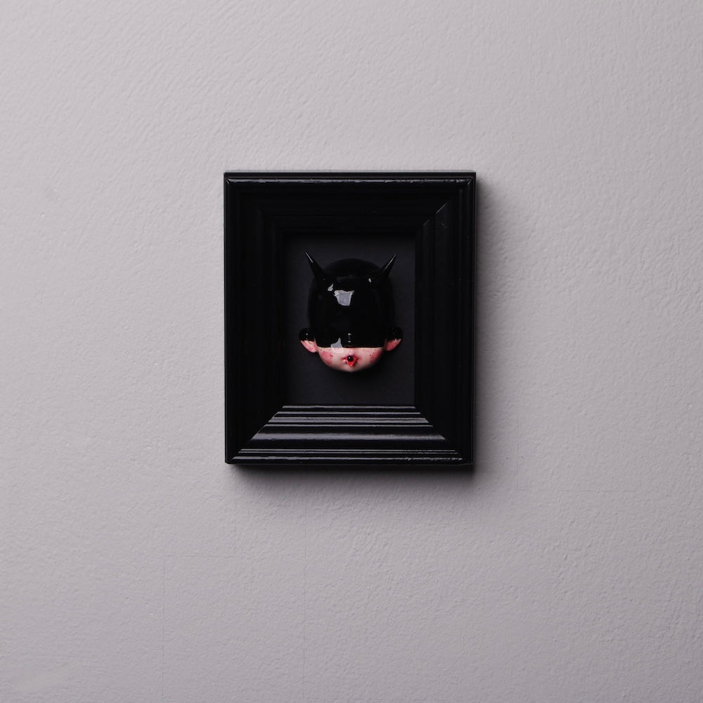 quadretto nero con testa di bambola con maschera nera e corna