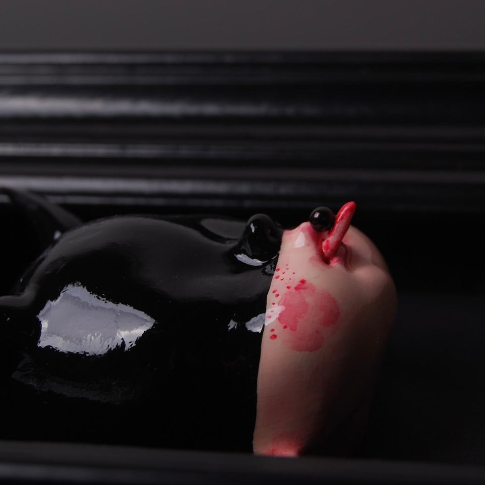 quadretto nero con testa di bambola con maschera nera e corna, particolare del profilo della testa