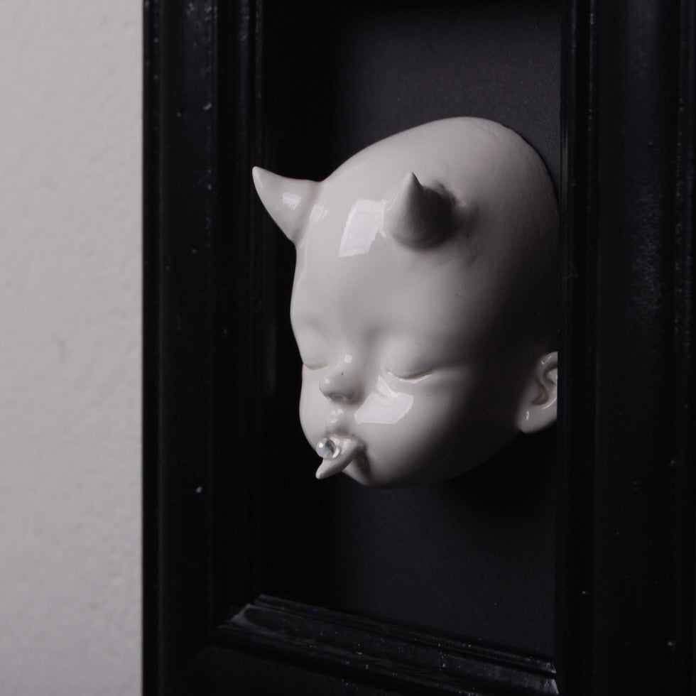 quadretto nero con testa di bambola bianca con corna vista 3/4