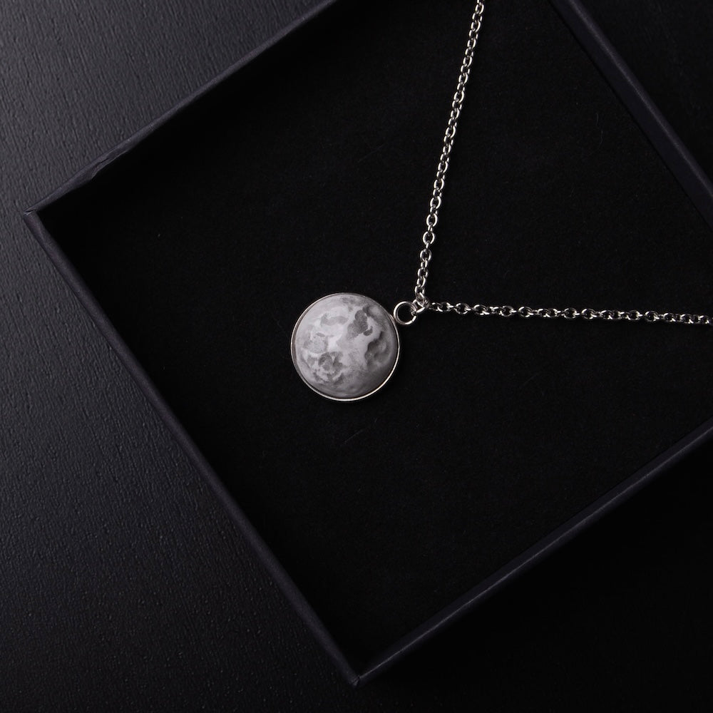 collana con pendente cabochon con luna piena dentro una scatolina nera, vista dall'alto