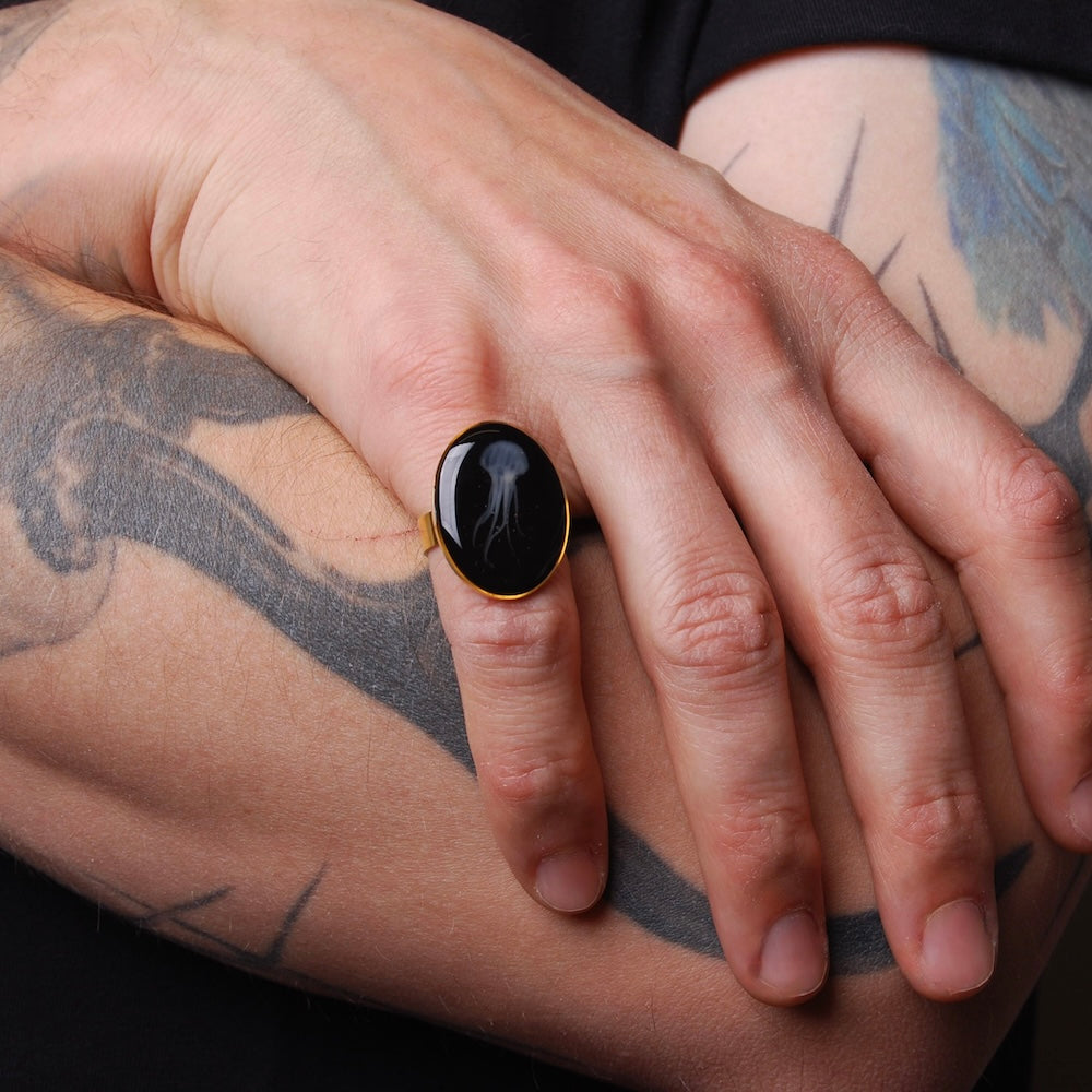 anello ovale con medusa sotto resina indossato in mano maschile