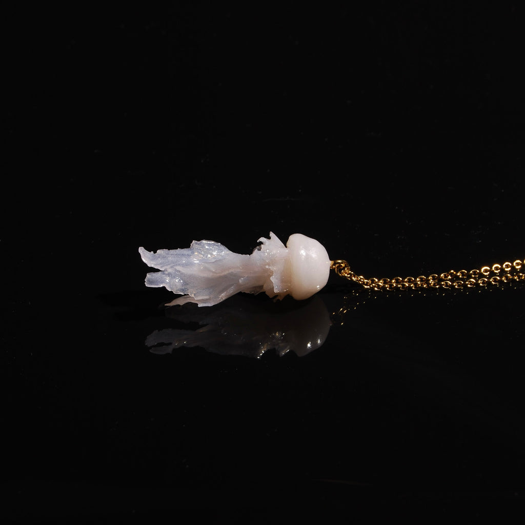 collana catena sottile con pendente medusa marina, poggiata lateralmente su fondo nero