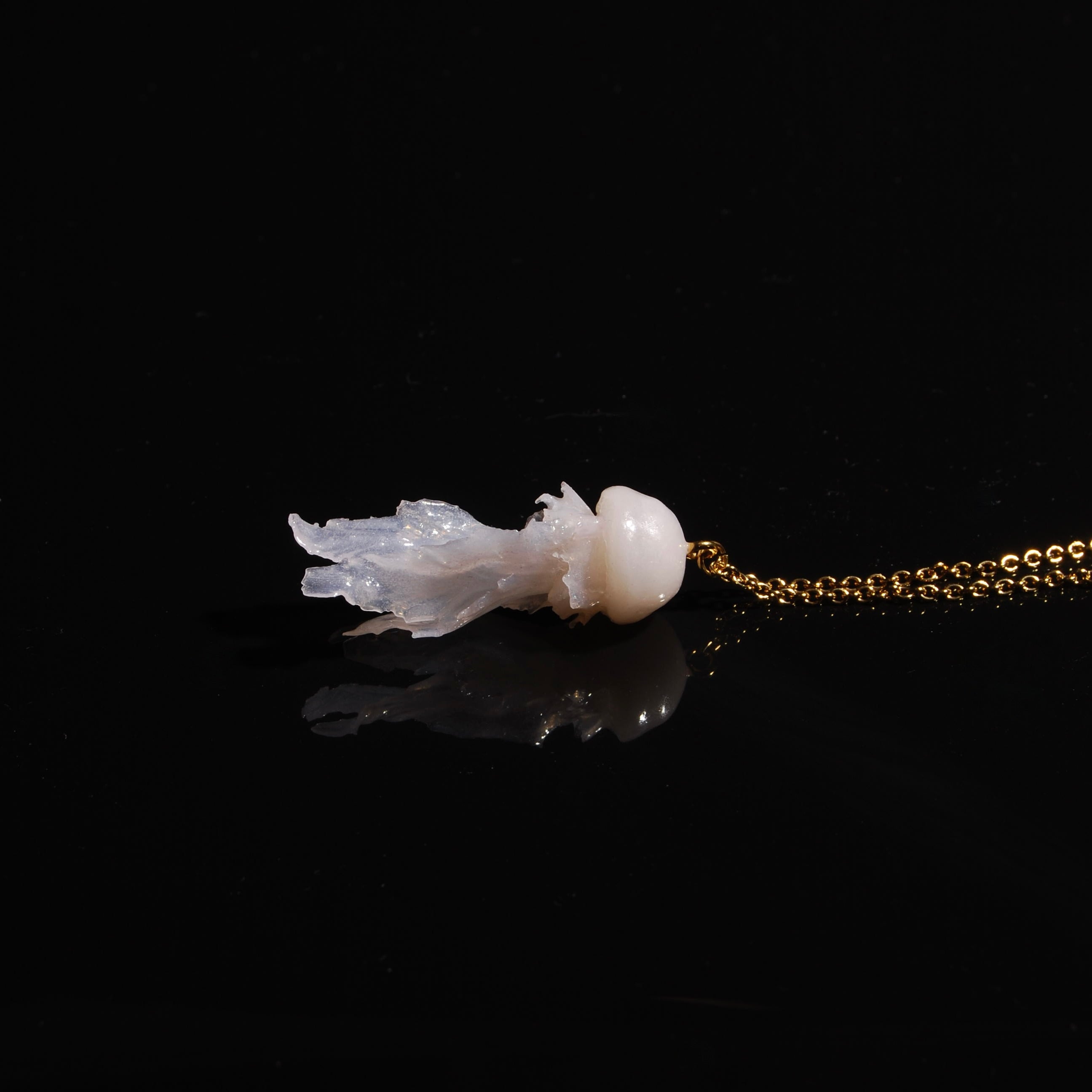collana catena sottile con pendente medusa marina, poggiata lateralmente su fondo nero