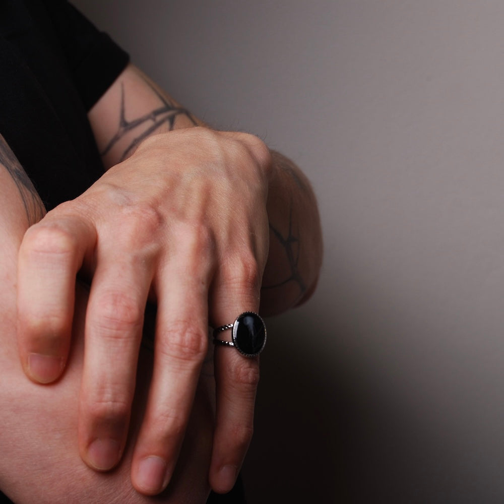 anello ovale con piccola medusa inglobata sotto resina indossato su una mano maschile