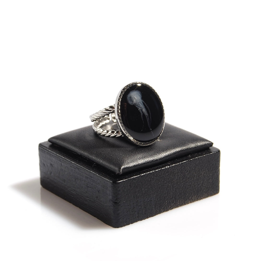 anello ovale con piccola medusa inglobata sotto resina, poggiato su un porta anelli nero