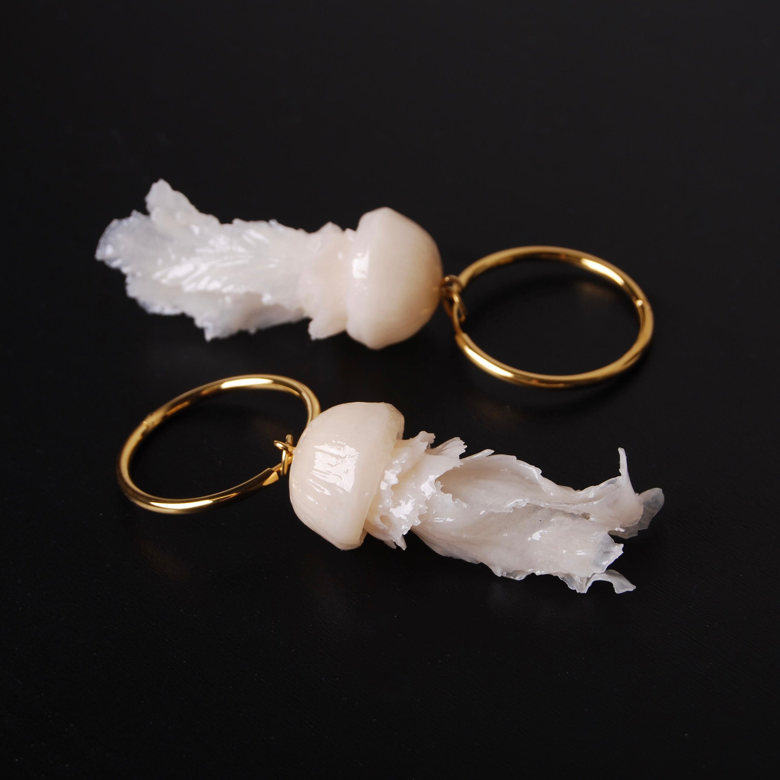 orecchini a cerchio con pendenti meduse, su sfondo nero