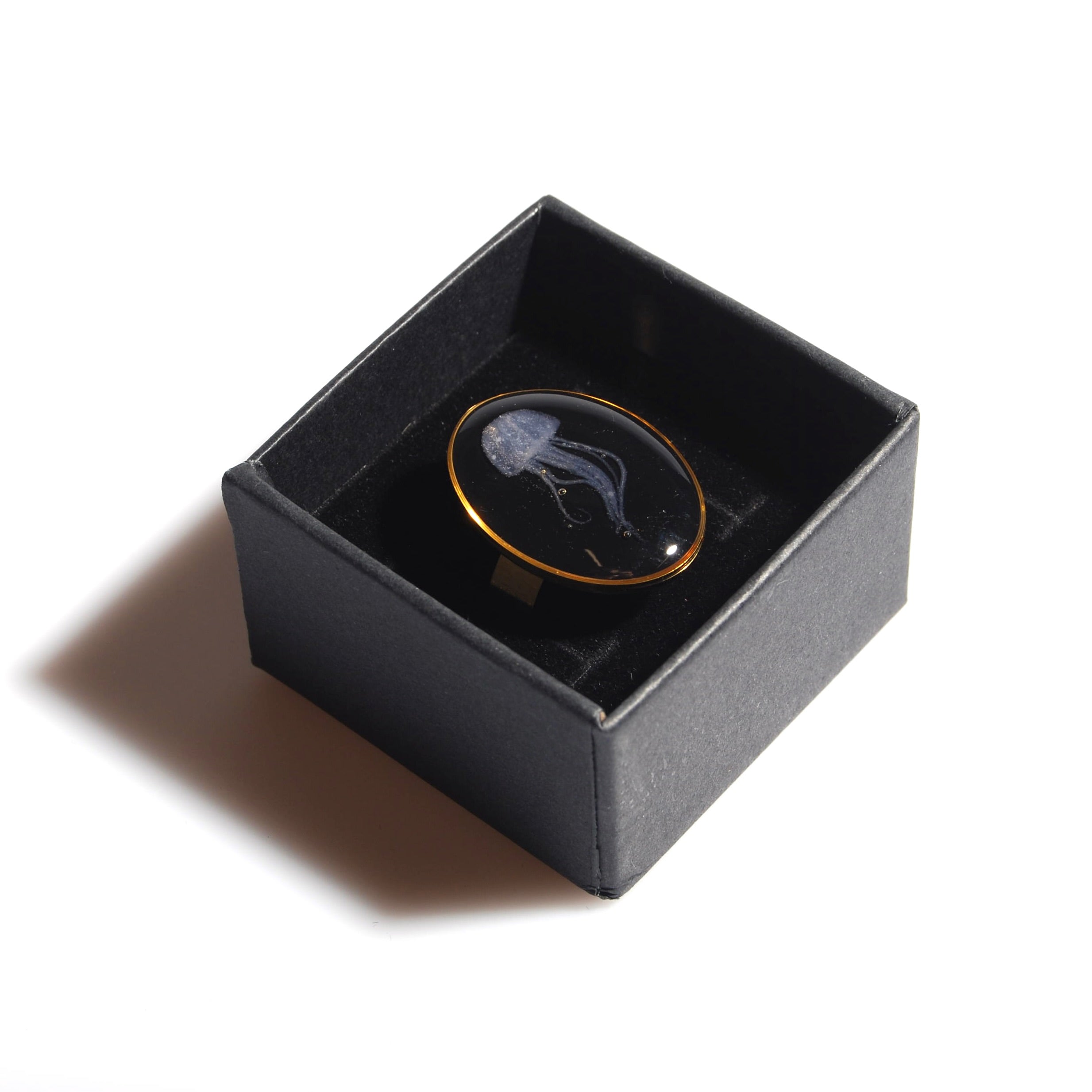 anello ovale con micro medusa, vista 3/4 dentro alla scatolina nera