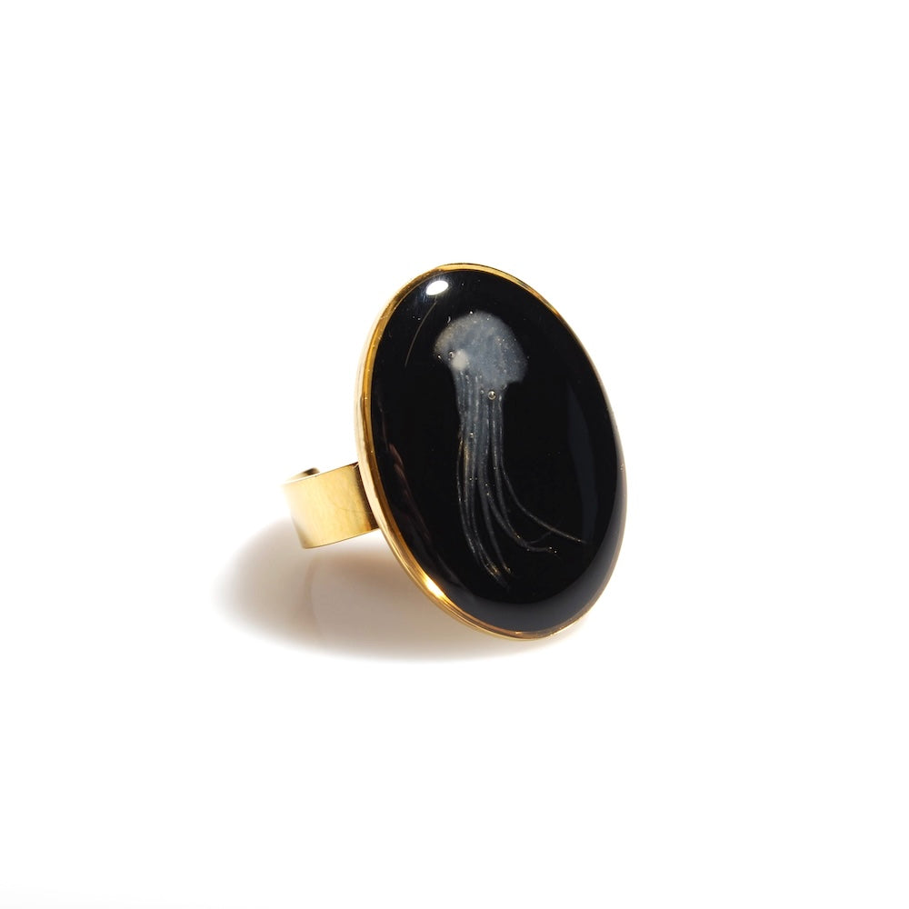 anello ovale con medusa marina inglobata sotto resina, vista 3/4