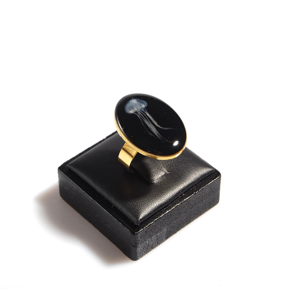 anello ovale con medusa sotto resina su porta anelli in legno