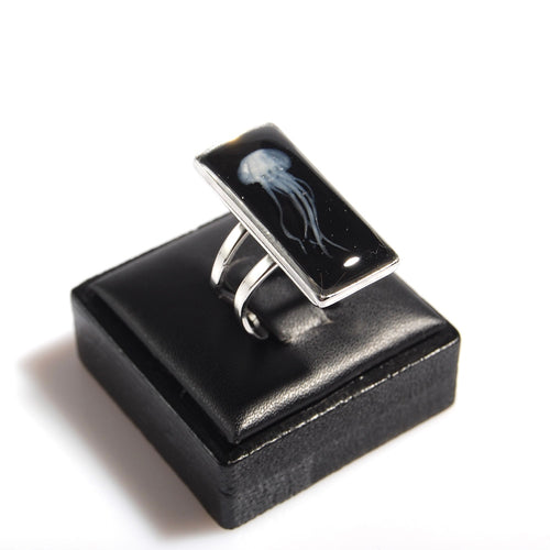 anello rettangolare con medusa inglobata sotto resina su espositore anelli in legno