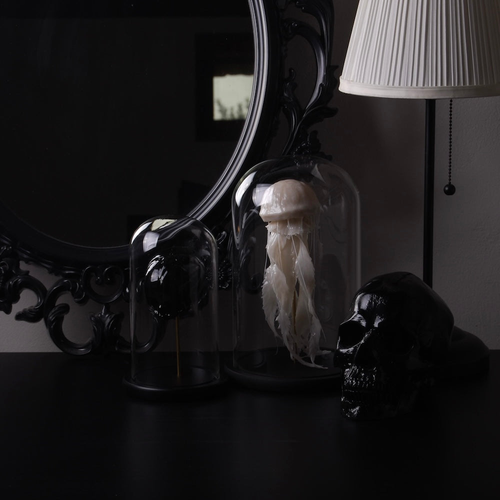 angolo decorativo con specchio barocco, lampada da tavolo, teche con medusa e teschio