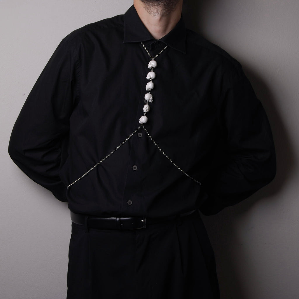 harness catena con teschi sulla parte frontale indossato su camicia nera