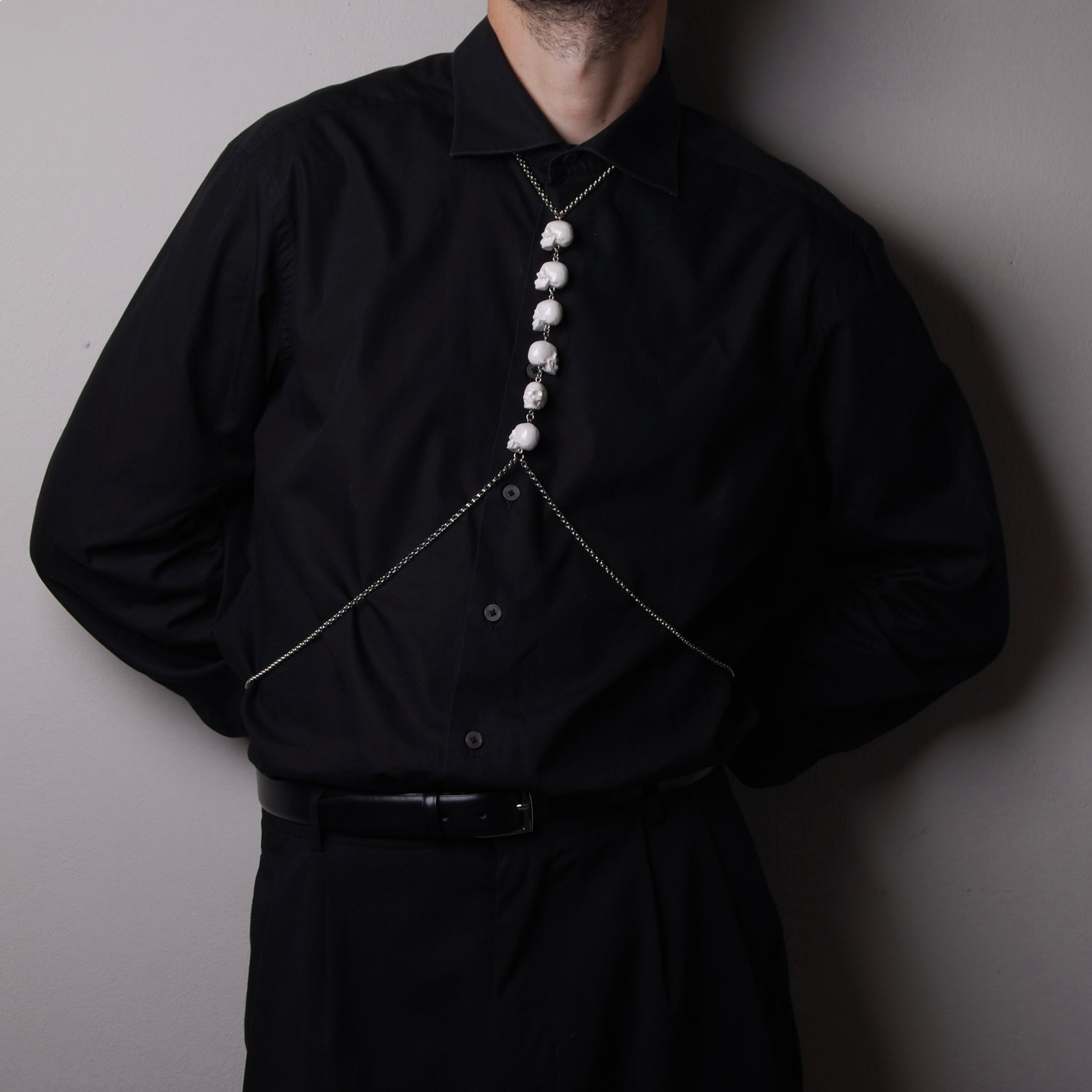 harness catena con teschi sulla parte frontale indossato su camicia nera