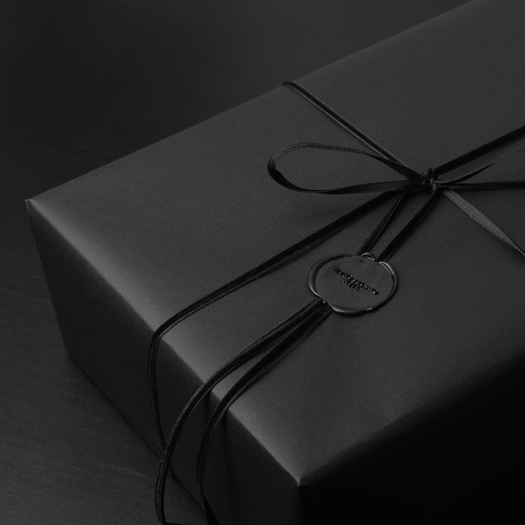confezione regalo nera con nastro in velluto nero e sigillo in ceralacca