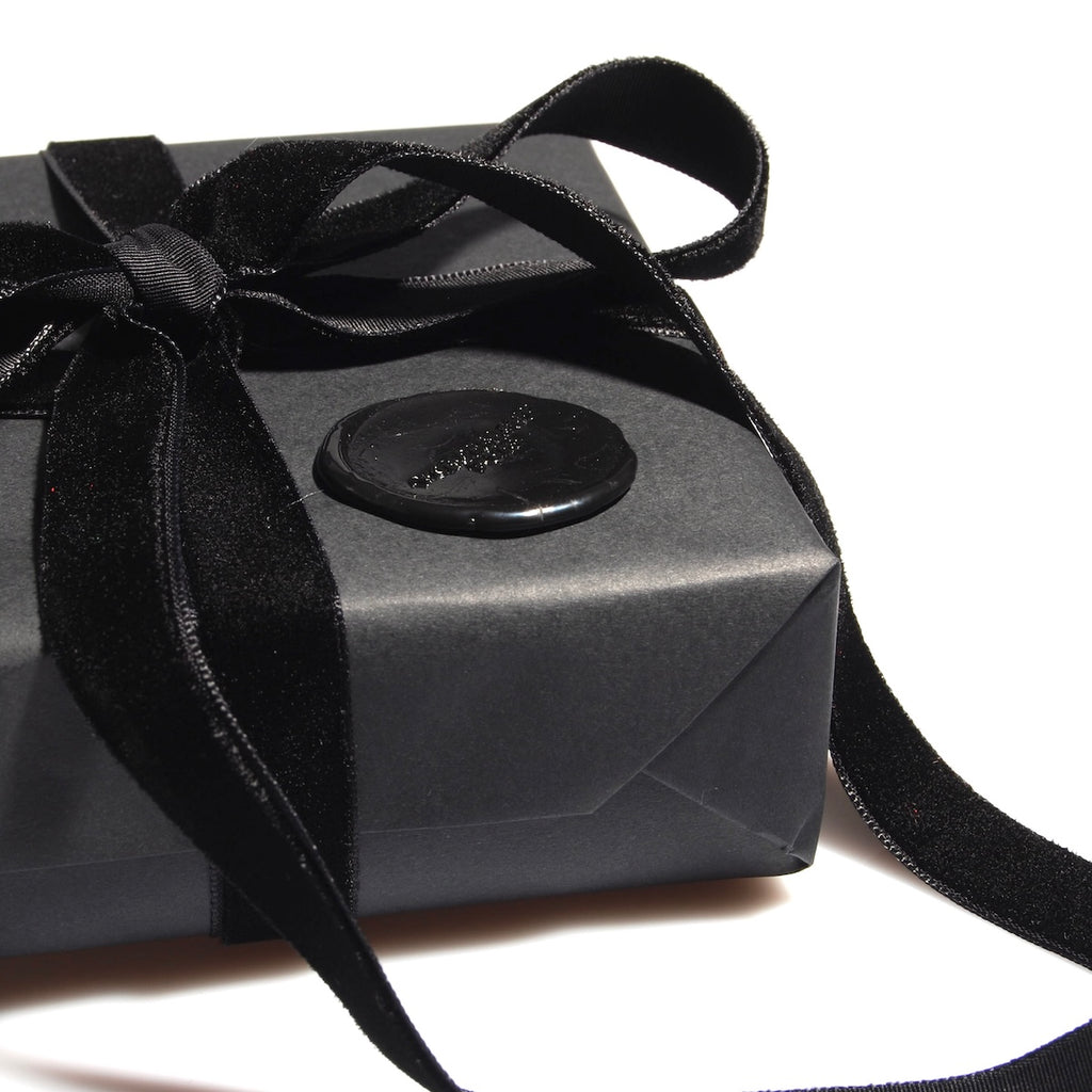confezione regalo nera con nastro in velluto nero e sigillo in ceralacca