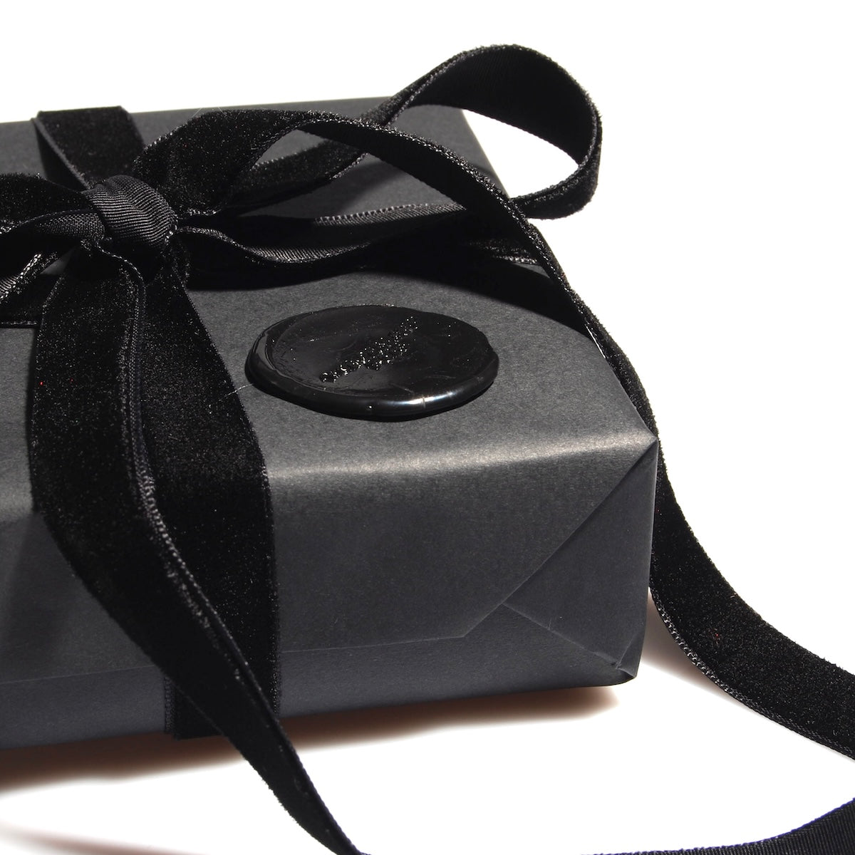 confezione regalo nera con nastro in velluto nero e sigillo in ceralacca
